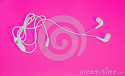 White Ear Phones On A Retro Pink Back Ground Up Close Stock Photo