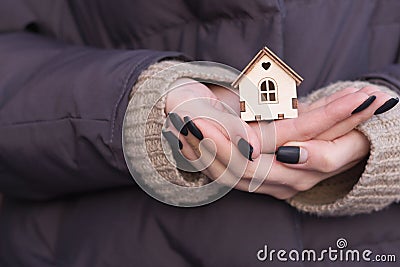 A small model of a wooden house stands on a hand. Concept image of my house Stock Photo