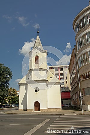 Small modest evangelic church in between modern apartment buildings Alba Iulia, Romania Editorial Stock Photo