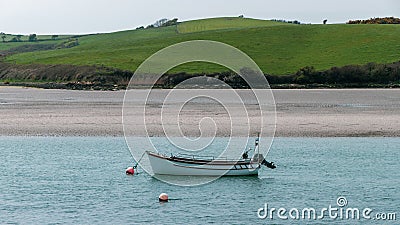 A small motor boat moored in shallow water. Sandy beach. Seascape. White boat on body of water Stock Photo