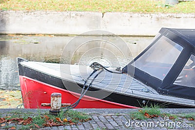 Small motor boat at the pier at channel. Side view. Stock Photo
