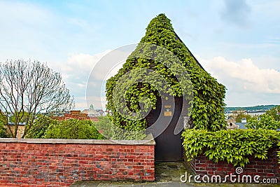 A small mystical door in the ivy-covered fence to the old Zamek Krolewski na Wawelu castle in the center of Krakow Stock Photo