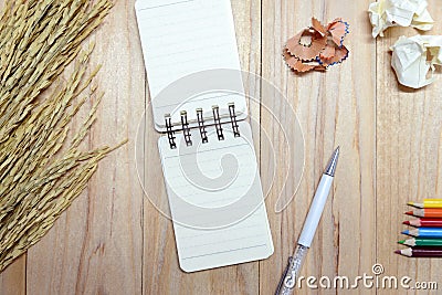 Small note book paper notepad for writing information with pen, color pencil and crumpled paper balls on wooden table Stock Photo