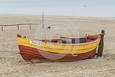 Old wooden clinket built fishing boat on a sandy beach Editorial Stock Photo