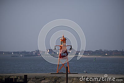 Small orange lighthouse on Esbjerg harbor in Denmark Stock Photo