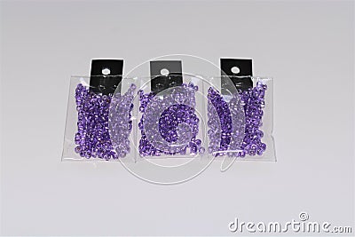 Small packs of shiny silver lined purple glass beads Stock Photo