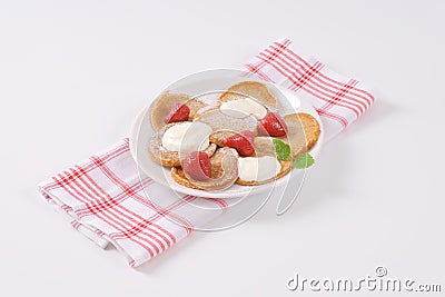 Small pancakes with cream and strawberries Stock Photo