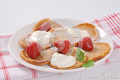 Small pancakes with cream and strawberries Stock Photo