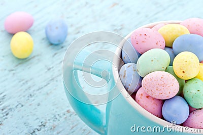 Small pastel easter eggs in a blue cup Stock Photo
