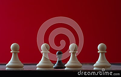 Small pawn on chess board against larger adversary concept of adversity ,discimination ,equality Stock Photo