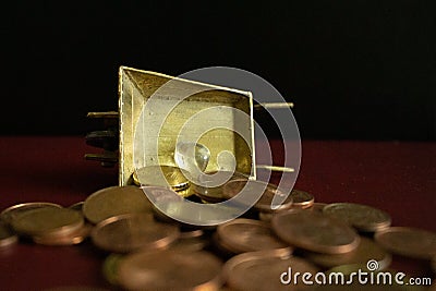 A small piece of clear crystal gemstone on a heap of money gold coins. Stock Photo