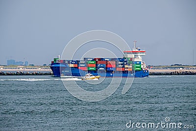 Small pilot boat passes sea going container ship Editorial Stock Photo