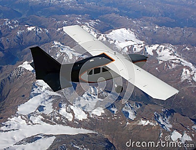 Small plane over mountains Stock Photo