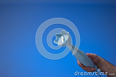 Small plastic hand food blender held in hand by male hand. Close up studio shot, isolated on blue background Stock Photo