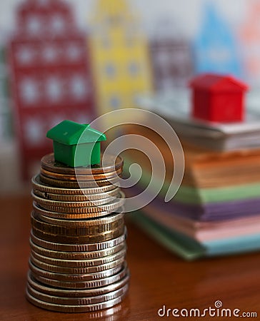 Small plastic house model on top of stacked coins Editorial Stock Photo