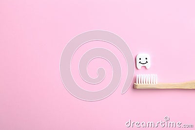 Small plastic tooth, wooden brush and space for text on color background Stock Photo