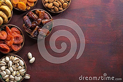 Small plates with dried fruits date palm fruits, dried apricots, figs and nuts pistachios, almonds for Iftar in Ramadan on the Stock Photo