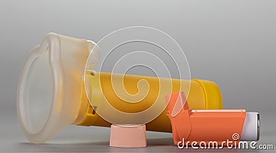 Small pocket inhaler for asthmatics and children`s mask, on gray Stock Photo