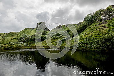 The small pond and reflected rocks of Faerie Castle Castle Ewen at the Fairy Glen in Isle of Skye, Scotland Stock Photo
