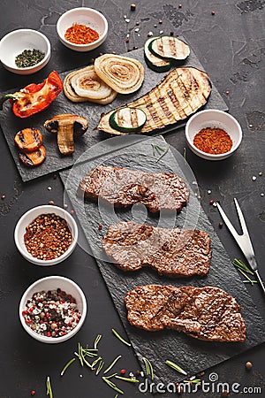 Small pork steaks on black background Stock Photo