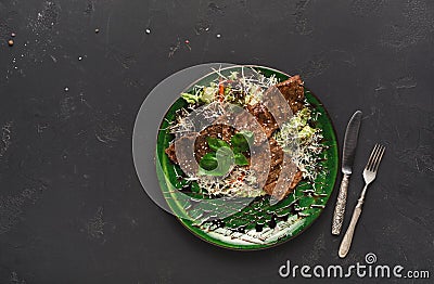 Small pork steaks on with salad black background Stock Photo