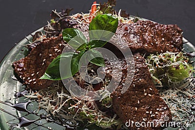 Small pork steaks on with salad black background Stock Photo