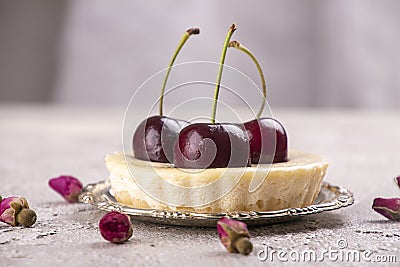 Small portion cheesecake with fresh sweet cherries against of gray background Stock Photo