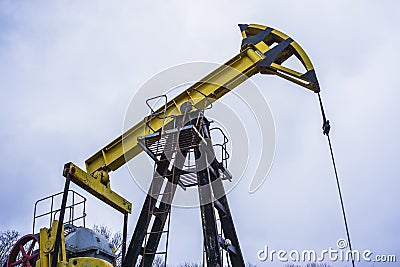 Small private yellow derrick pumps oil. Stock Photo