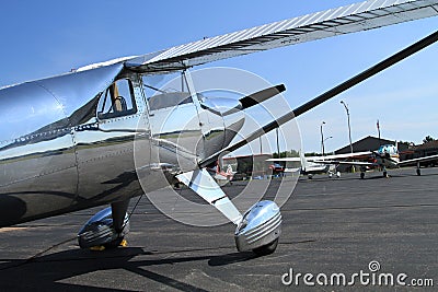 Small prop shiney metal aircraft at airport on tarmac Stock Photo