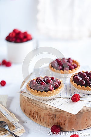 Small raspberry tarts on bright background Stock Photo