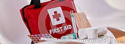 Small red First Aid kit with pills and bandages Editorial Stock Photo