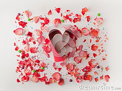 Small red heart made from red ribbon, on white background with rose petals . Composition for themes like love, valentine`s day, ho Stock Photo