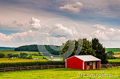 Small red stable and view of farms in Southern York County, Penn Stock Photo