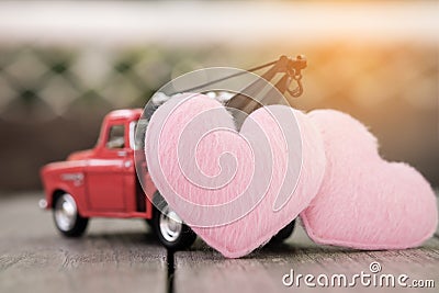 Small red toy car and pink hearts for valentine`s Day Stock Photo