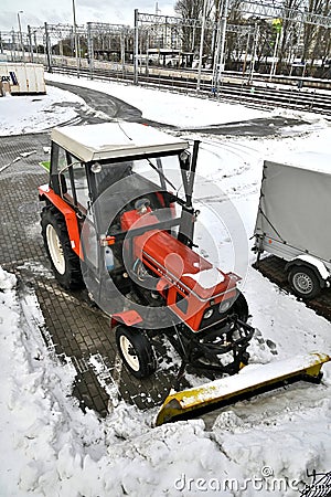 Small red tractor with snow plow for street cleaning Editorial Stock Photo