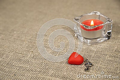 small red valentine and a candle on a coarse texture Stock Photo