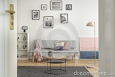 Small round wooden coffee table in front of trendy sofa in elegant interior Stock Photo