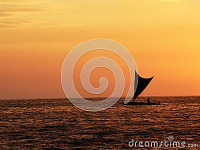 Small sail boat silhouette sailing background burnt orange sunset Stock Photo