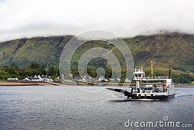 Small sailboat gliding through the calm waters of a tranquil lake surrounded by majestic mountains Editorial Stock Photo