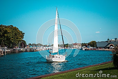 Small sailboat returning to harbor in South Haven Michigan Editorial Stock Photo