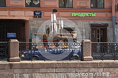 A small sailing ship on the roof o the car in the city street Editorial Stock Photo