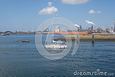 Small sailing yacht sails out of IJmuiden seaport towards the No Editorial Stock Photo