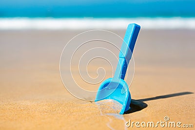 Small shovel in the sand on the beach Stock Photo