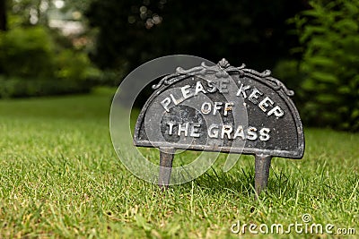 The small sign with a text Please keep off the grass to protect lawn Stock Photo