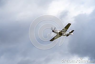 Small single engine airplane flying in the english cloudy sky Editorial Stock Photo