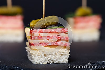 Small snacks canape with salami, cheese and pickle on skewer on Stock Photo