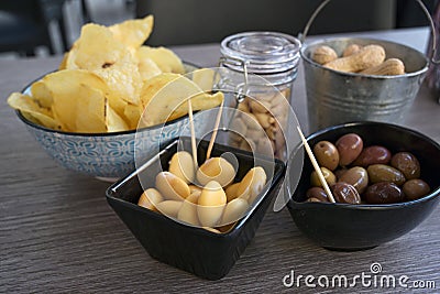 Small snacks like beans, olives, nuts and chips on a table in an outdoor bistro, selected focus Stock Photo