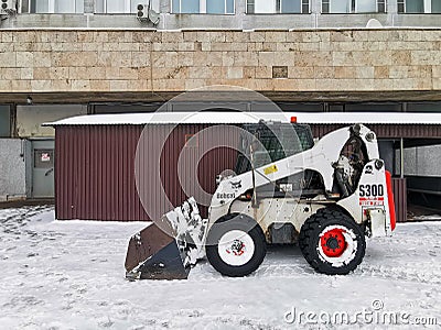 A small snowplow Bobcat backhoe loader. Editorial Stock Photo