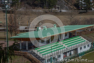 Small spectator stand of a soccer field with green seats. Stock Photo