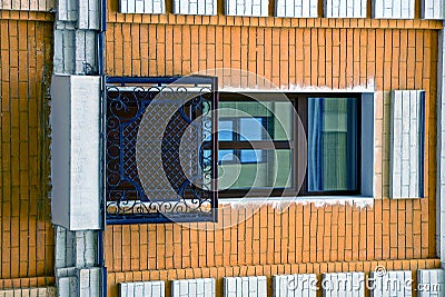 A small square balcony and a door with a window on the wall of a modern building Stock Photo